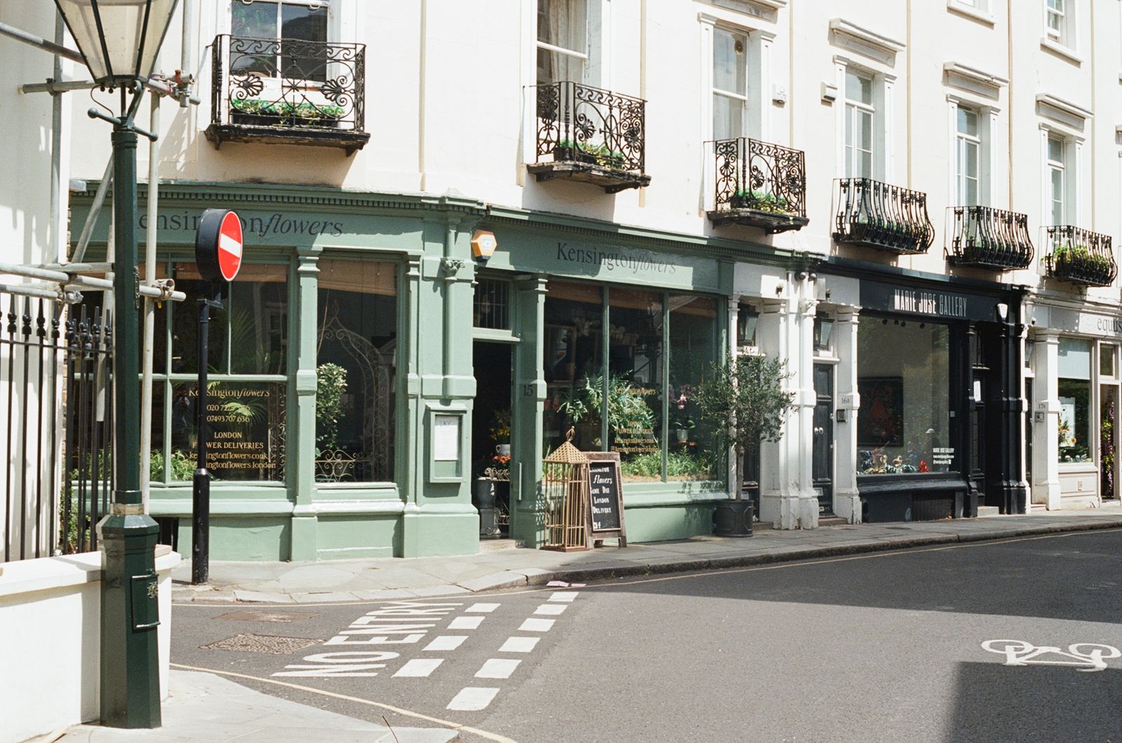 A distinctive UK shopfront on a corner, with its own colour, signage, and window display