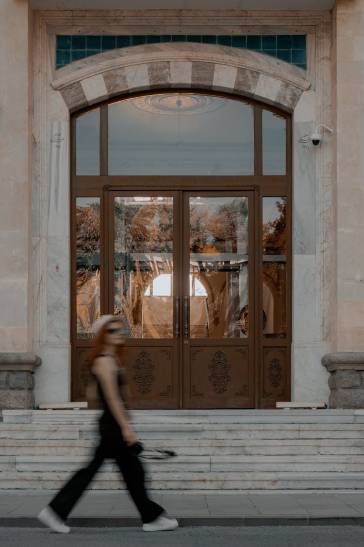 Woman Walking Near Building Stairs And Door