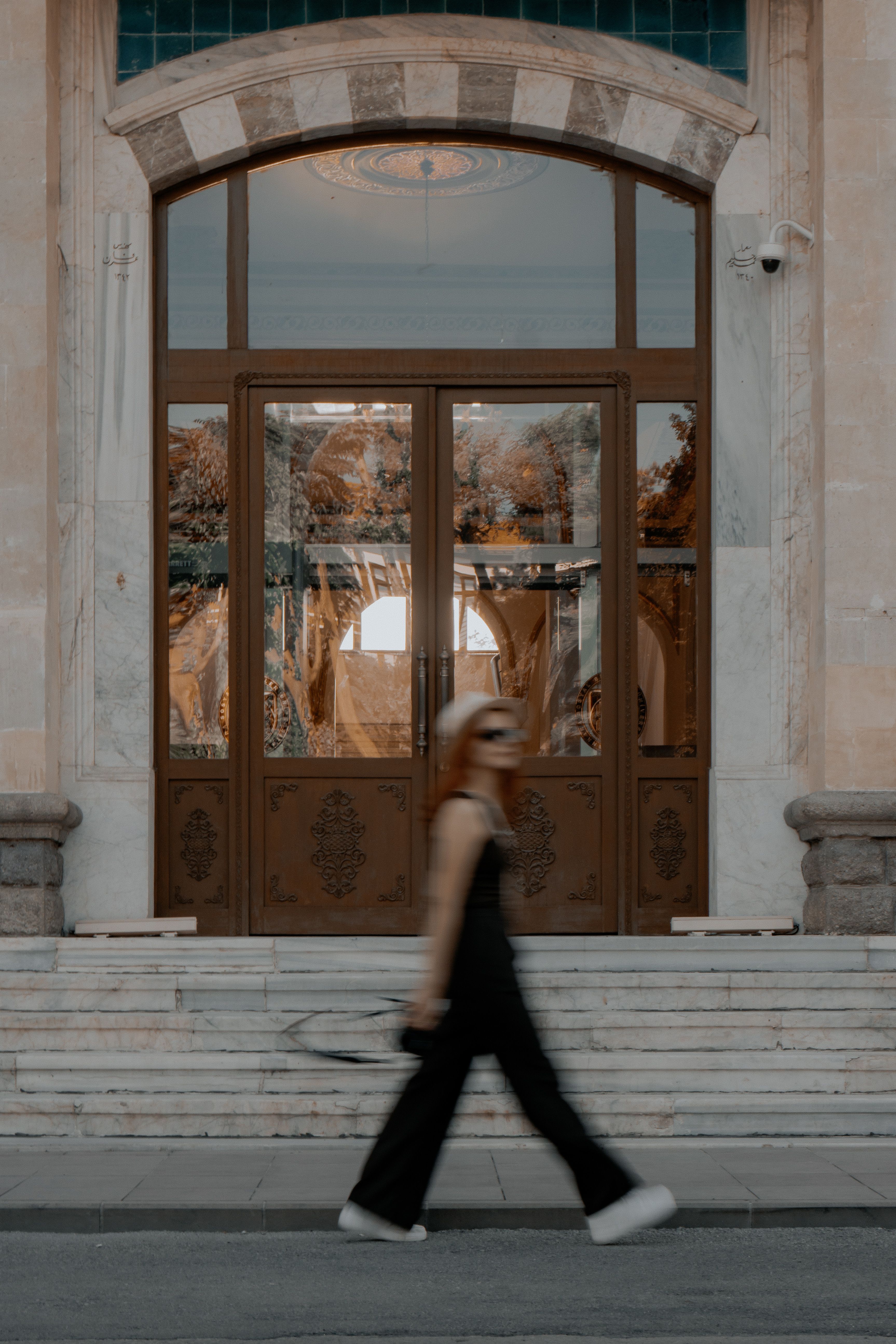Woman Walking past a Glass Entrance Door · Free Stock Photo