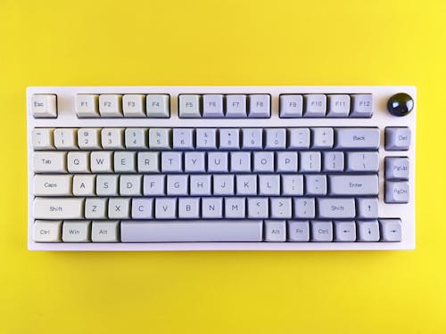 A Computer Keyboard on Yellow Background 
