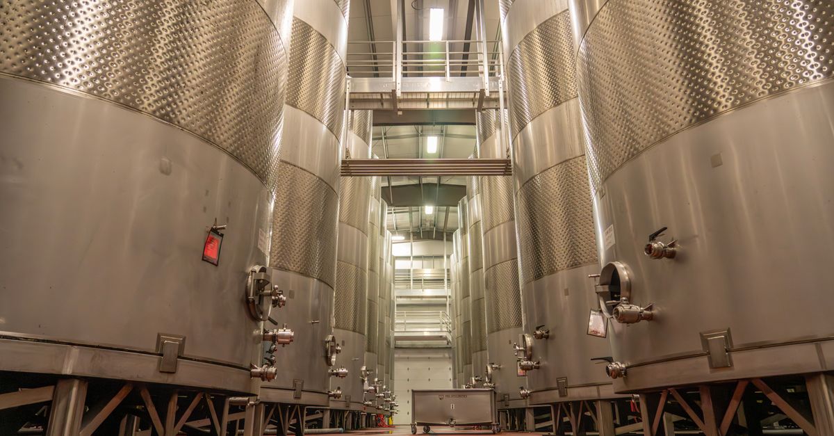 precision fermentation tanks with glowing liquid and scientists monitoring