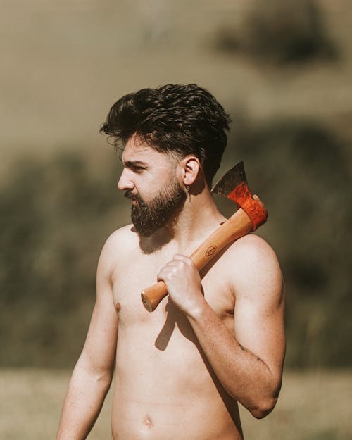 Shirtless Man Holding Axe on Shoulder