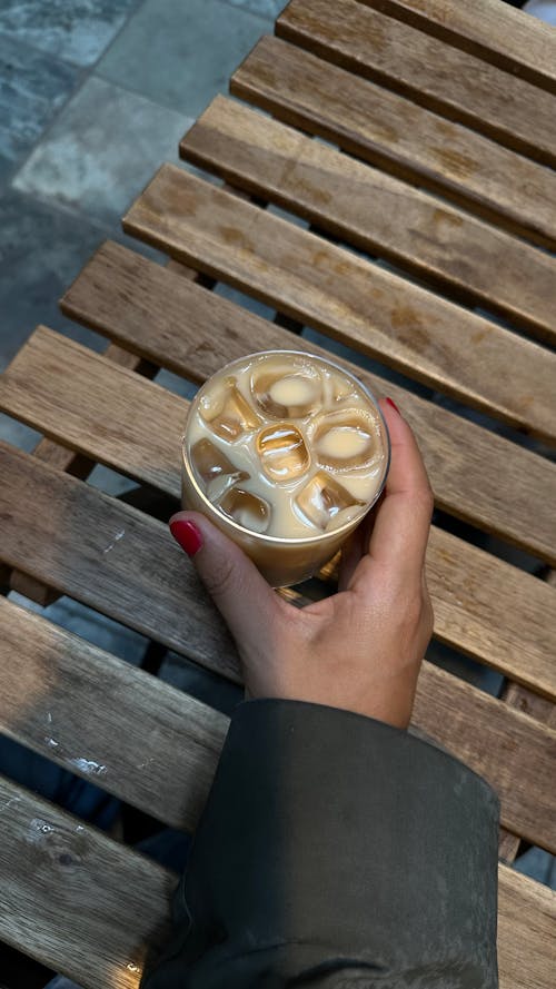 Woman Hand Holding Glass of Coffee with Ice