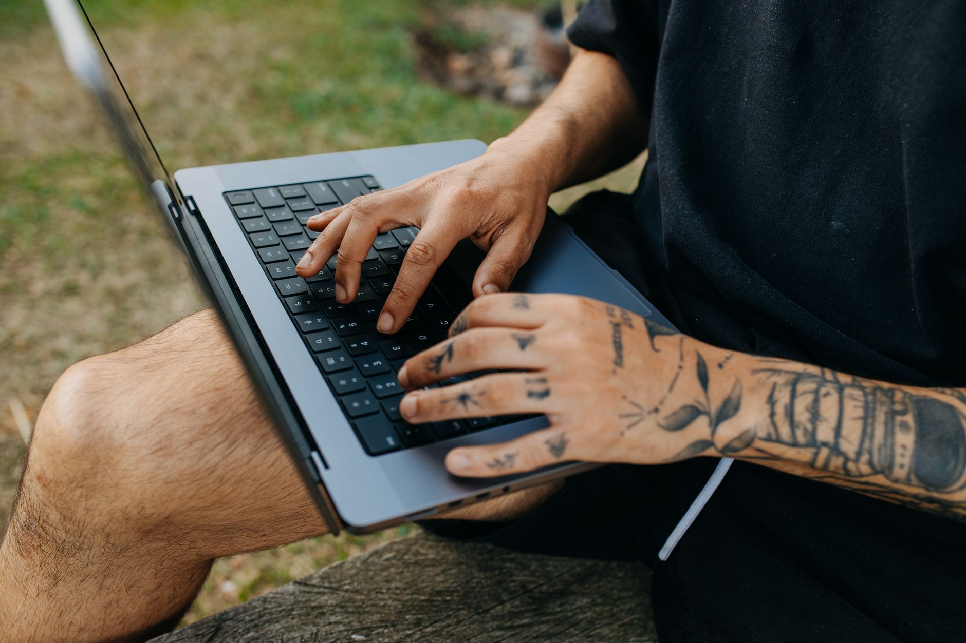 Man using a laptop on a bench while checking account and browser settings.