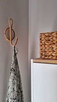 Stylish corner showcasing a rattan hook and wicker basket against simple decor.