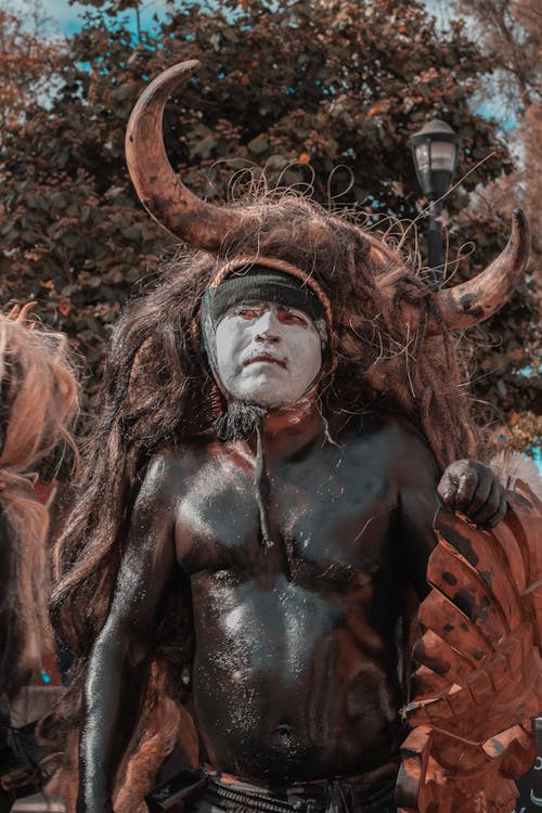 Man Standing in Ritual Costume on Buffalo