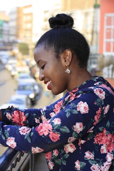 阳光明媚的一天，一名女子靠在户外的栏杆上微笑