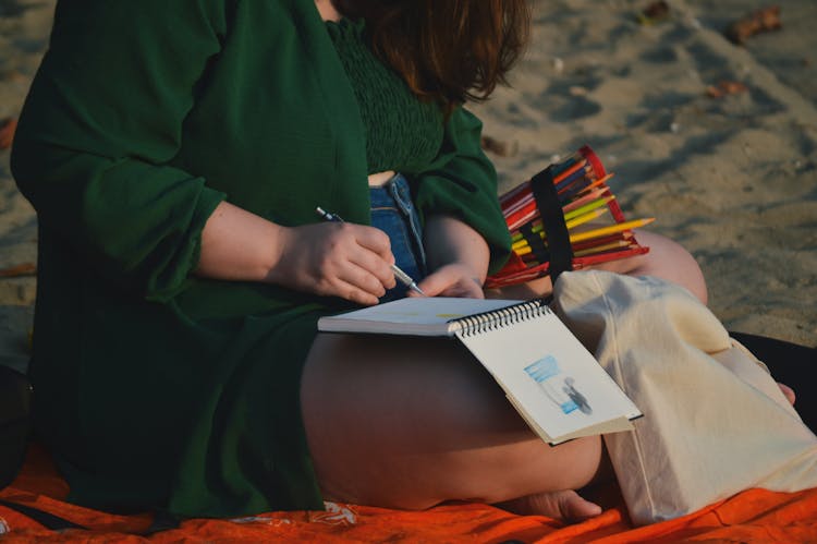 Woman Sitting On The Beach And Drawing 