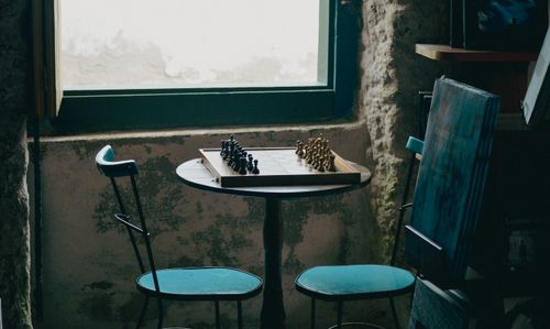 Free Empty room with chessboard on table by window. Atmospheric and serene. Stock Photo