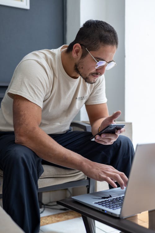 Free Man Using a Laptop in the Living Room  Stock Photo