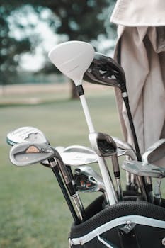 Golf clubs neatly arranged in a bag at an outdoor golf course.