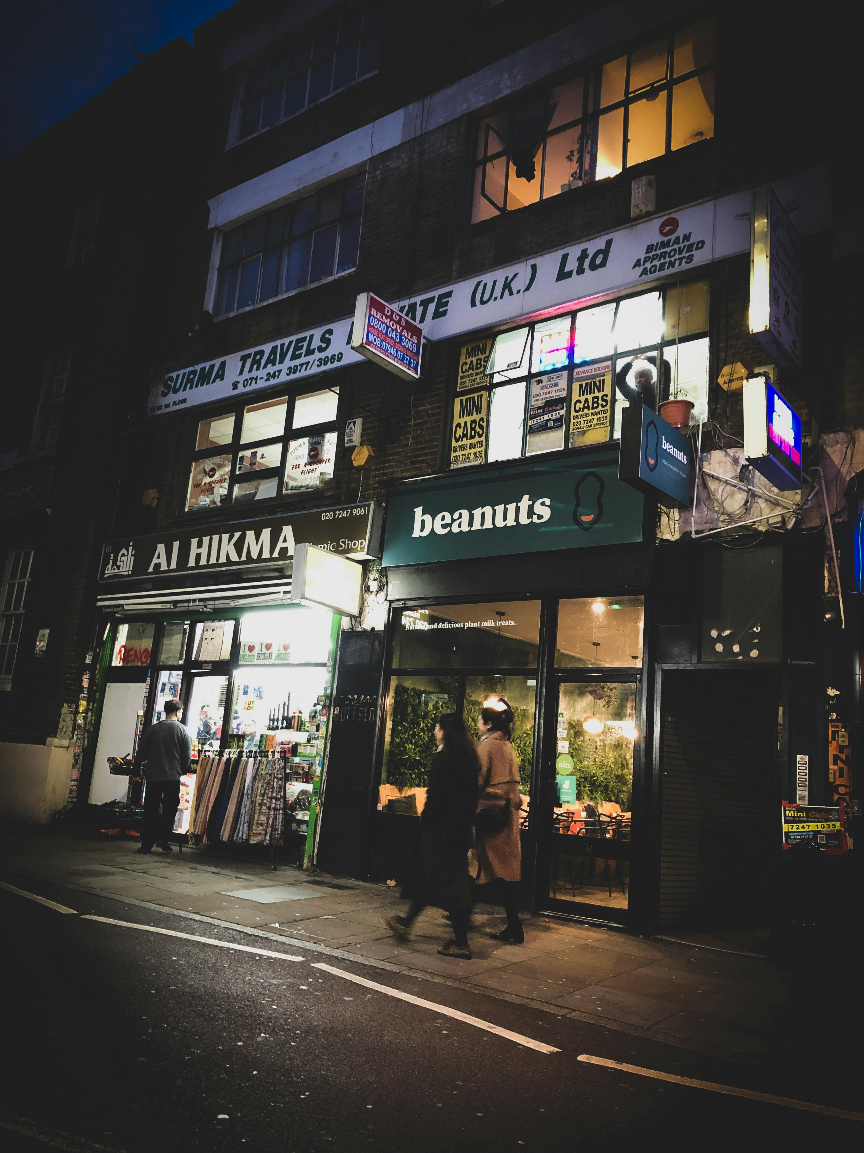 夜晚的街景中，灯火通明的商店和来往行人，共同营造出充满活力的城市氛围