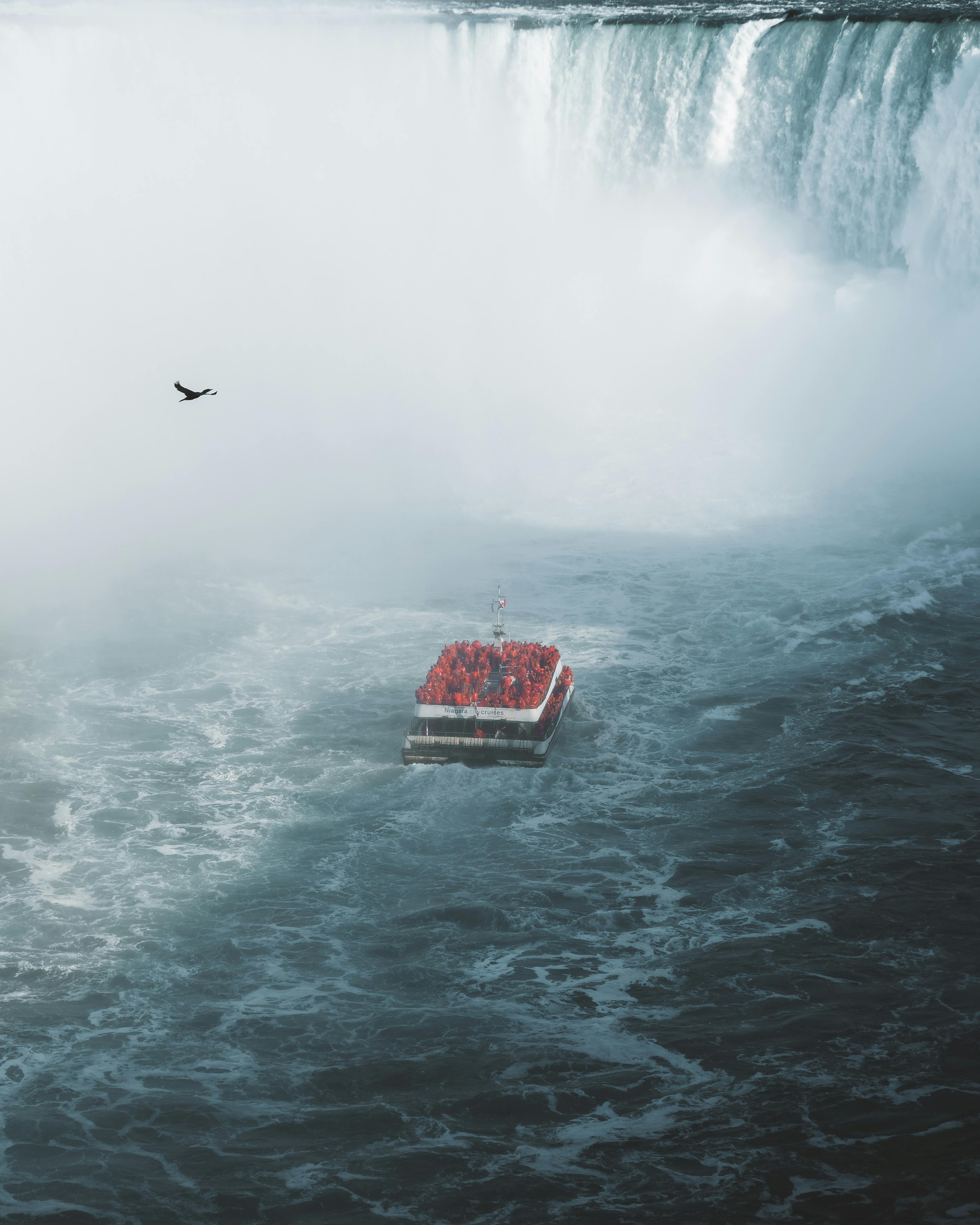 A tourist boat braves the misty waters near the majestic Niagara Falls, showcasing adventure and natural beauty.
