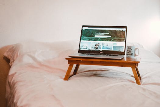 舒适的家庭工作空间，配有床、笔记本电脑和咖啡，非常适合在舒适的环境中进行远程工作