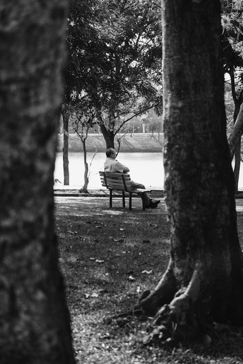 Man Sitting on a Bench in Black and White