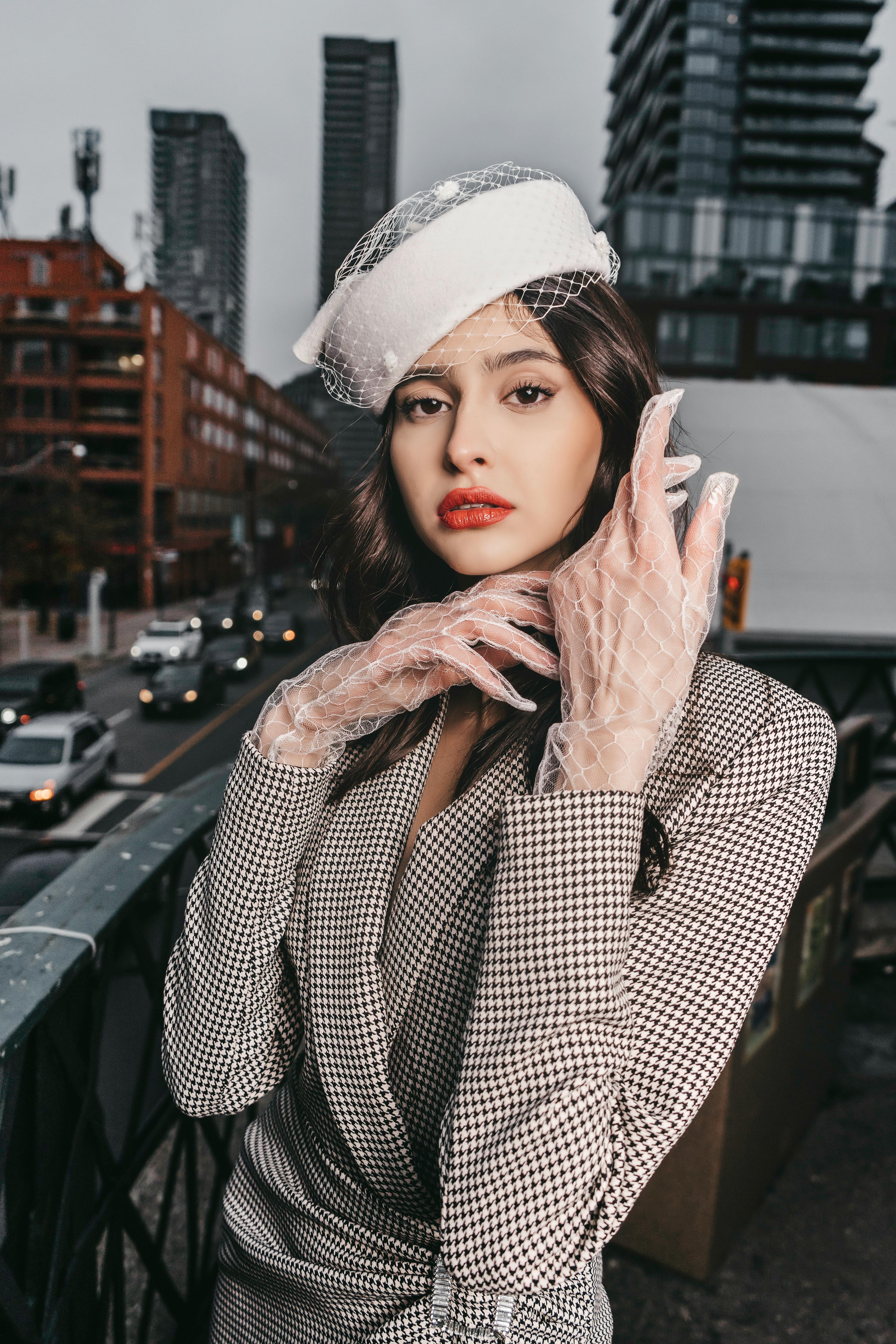 a woman in a white hat and gloves posing for a photo