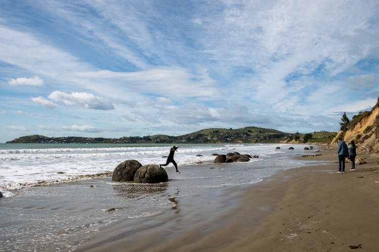 People Walking And Running On Beach