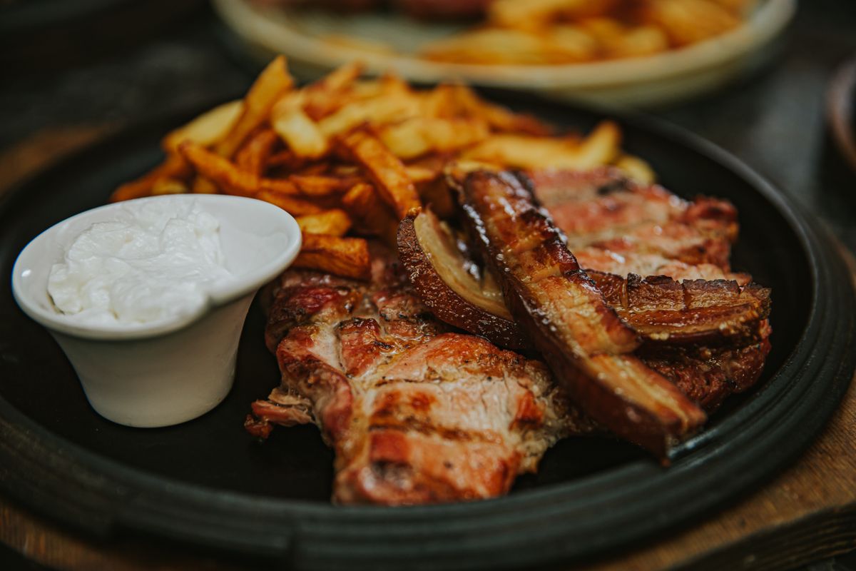 Grilled pork neck steaks and crispy pork belly strip with fries and white garlic dip