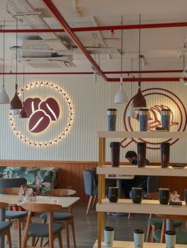 Stylish café interior featuring modern furniture and coffee-themed decor, ideal for cozy gatherings.