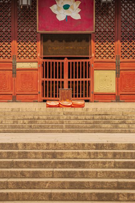 Elegant temple entrance with steps and seating for meditation, highlighting spiritual tranquility.
