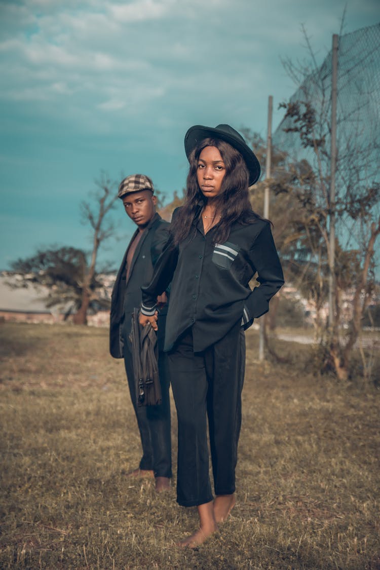 Couple Standing On Meadow In Black Clothes