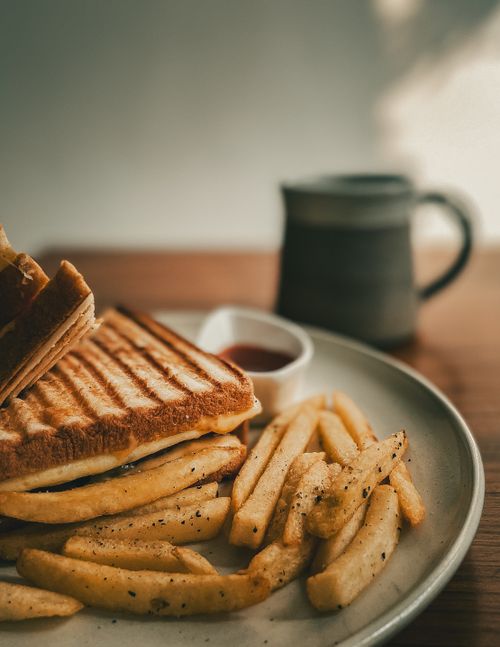 Free Tasty grilled cheese sandwich with crispy fries and ketchup on a plate, perfect for a savory meal. Stock Photo