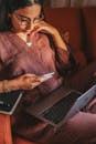 A Woman Sitting with a Smartphone and a Laptop