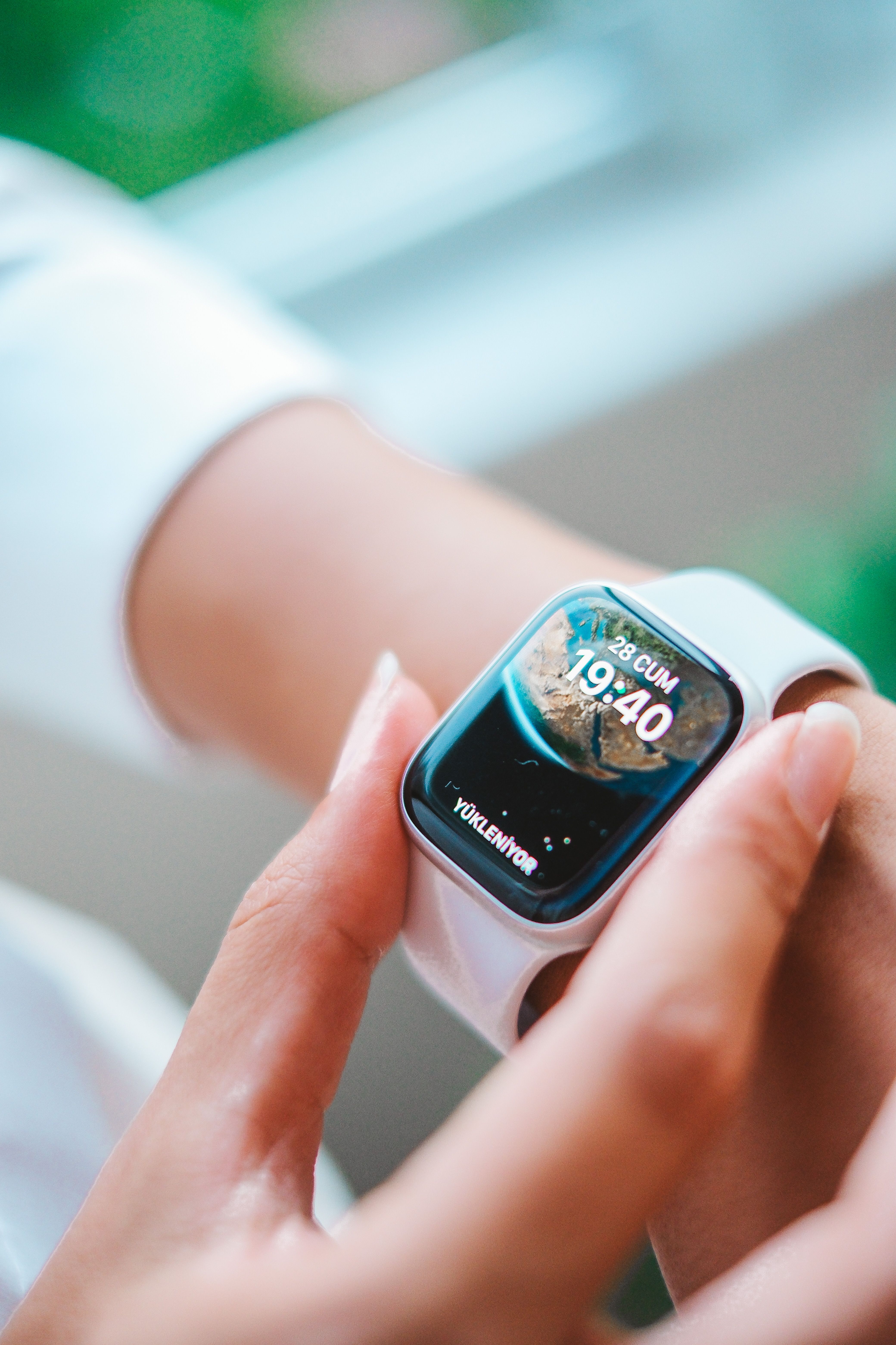 Close-up of a person's hand adjusting a smartwatch indoors. Technology focus.
