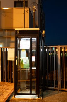 A brightly lit telephone booth in Ayabe, Kyoto, captured during nighttime.
