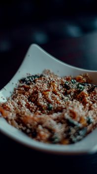 Appetizing salad topped with sesame seeds in a white bowl, perfectly seasoned.