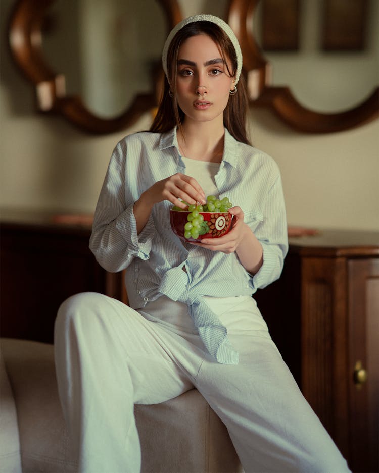 Woman Sitting And Eating Grapes