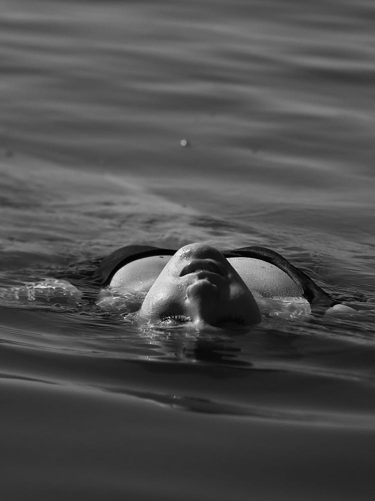 Woman Swimming On Back In Sea