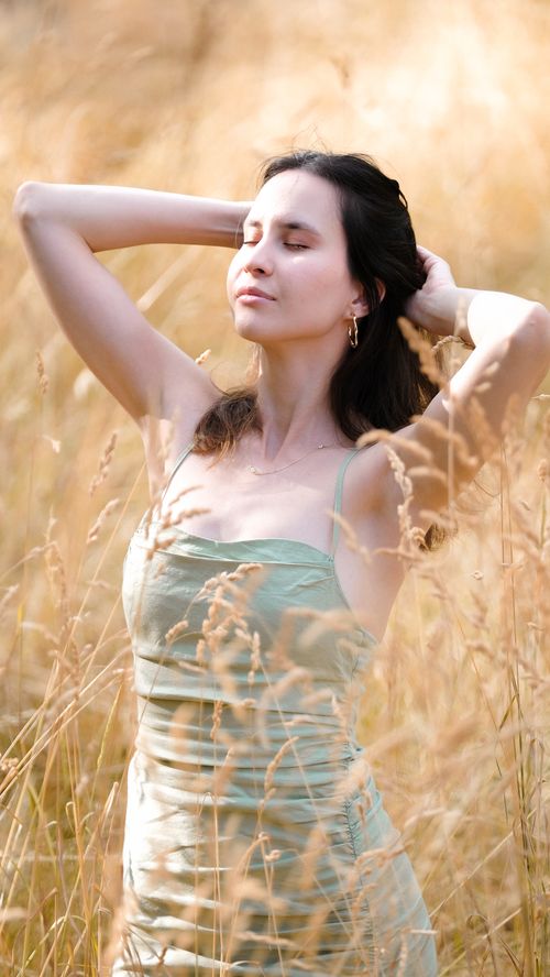 Free Fashionable woman enjoying sunlight in a summer field. Stock Photo