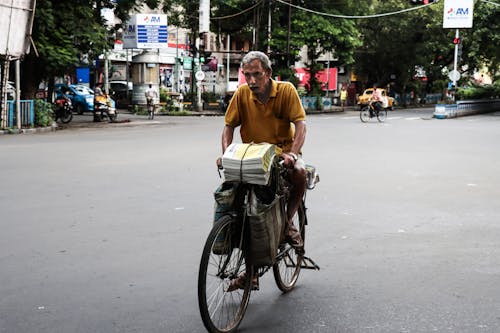 Man Carrying Newspaper on Bike