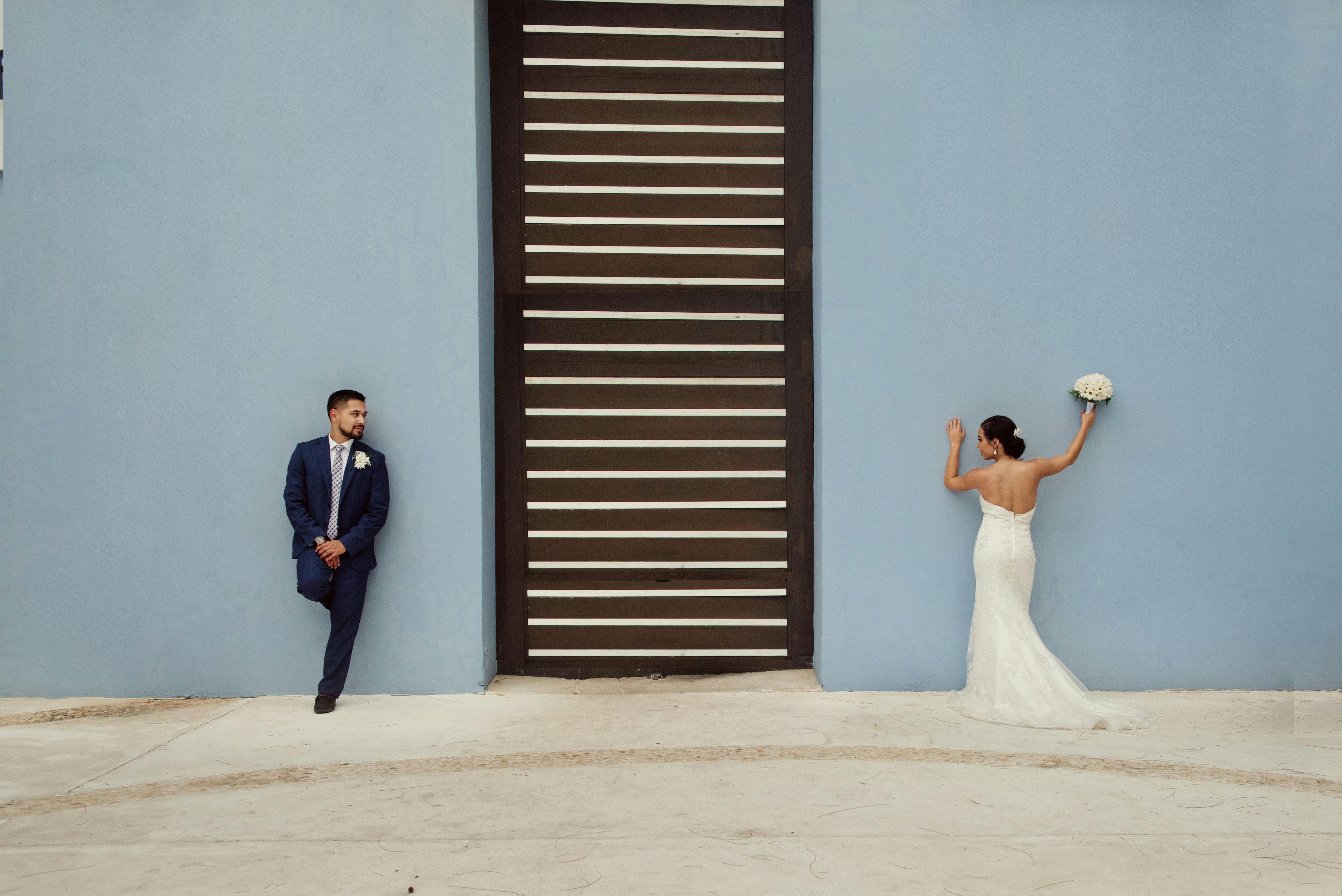 Newlyweds Leaning On Blue Wall