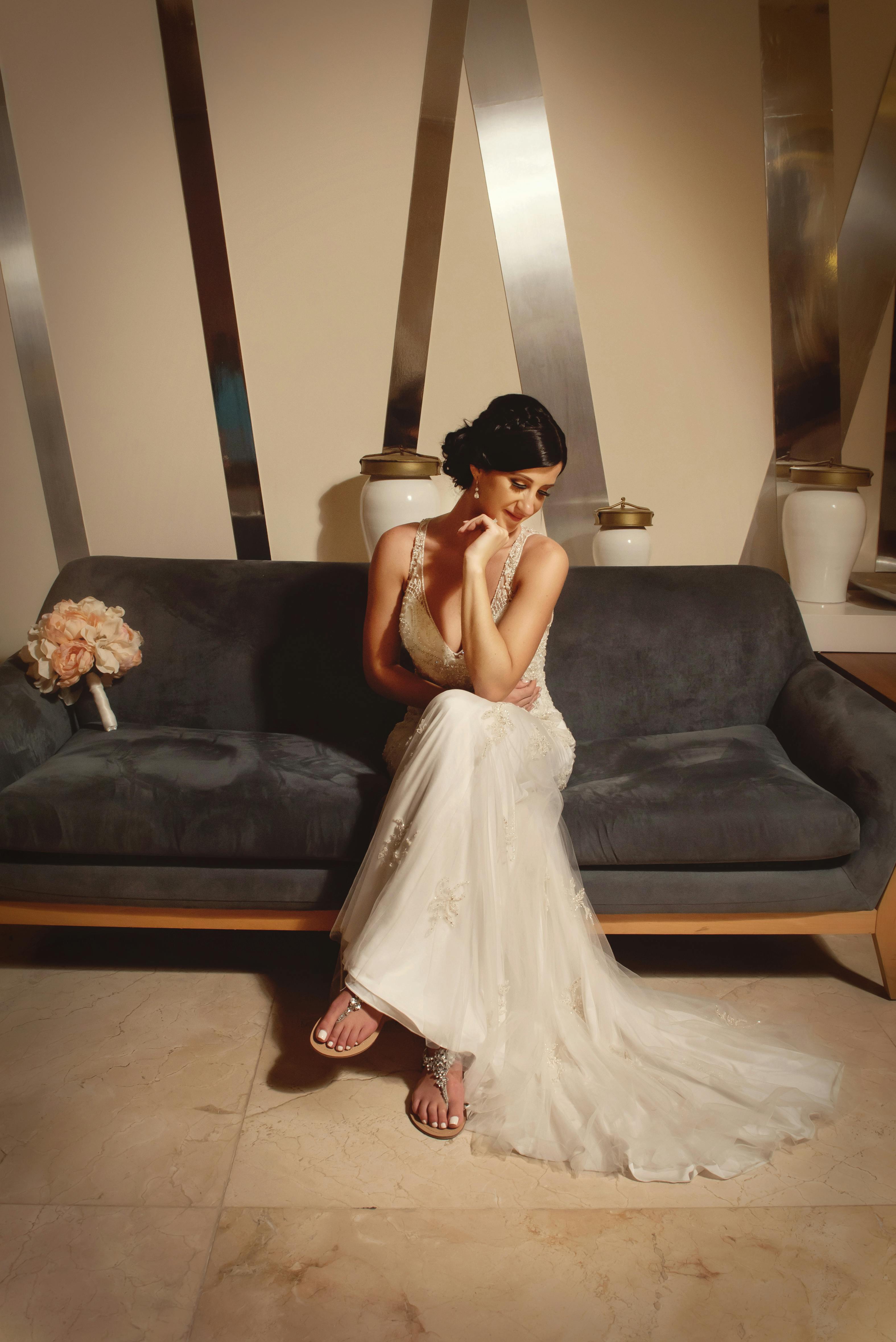 身着白色礼服的新娘令人惊叹地坐在沙发上，室内布置优雅