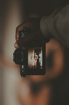 A creative studio portrait captured through a camera's viewfinder, showcasing a woman in focus.