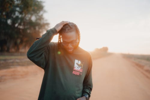 A Man Standing Outdoors at Sunset