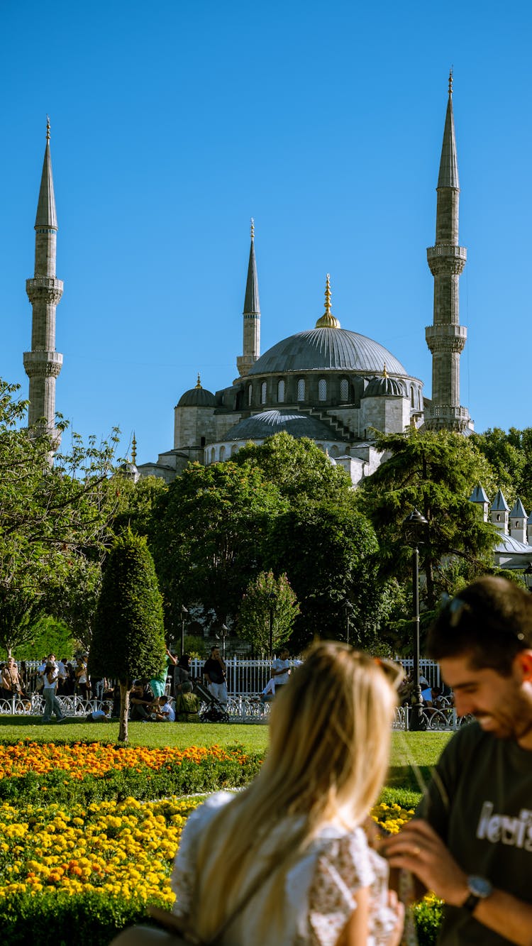 People Standing In Front Of A Mosque