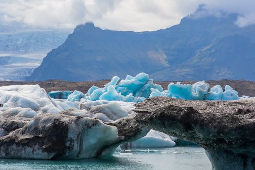 Breathtaking view of glaciers and icebergs against dramatic mountain backdrop.