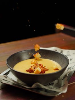 Delicious bowl of creamy soup garnished with bacon and croutons.