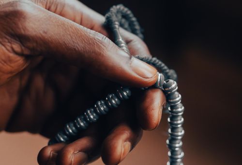Free A close-up view of a hand holding prayer beads, symbolizing spirituality and meditation. Stock Photo