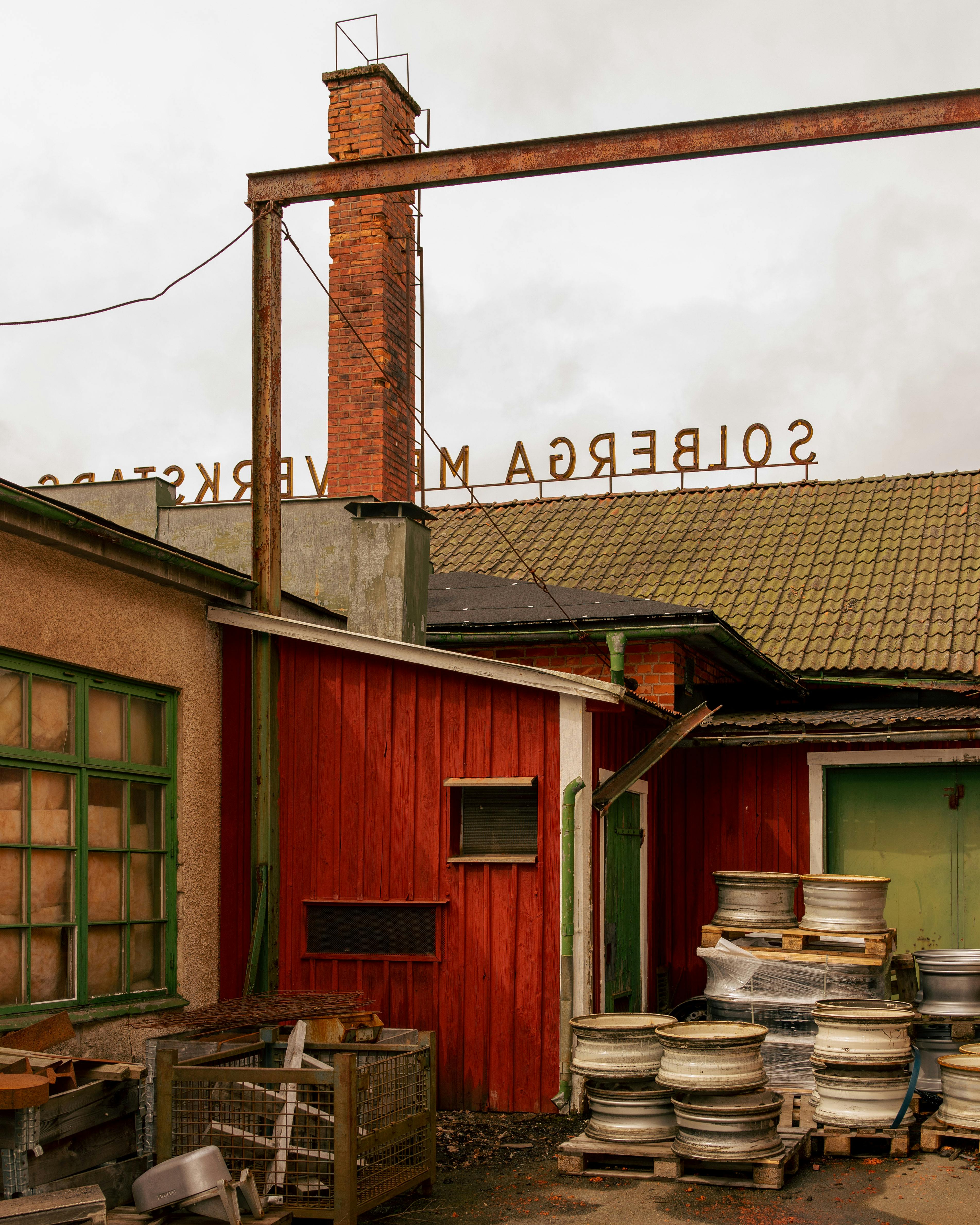 Vintage industrial building with chimney in Sweden, showcasing rustic architecture.