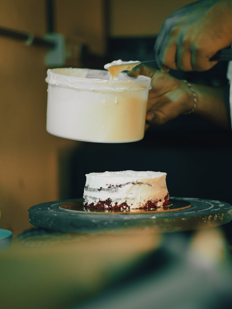 Close-up Of A Person Decorating A Cake 