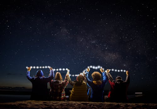 People Sitting Together with Lights at Night