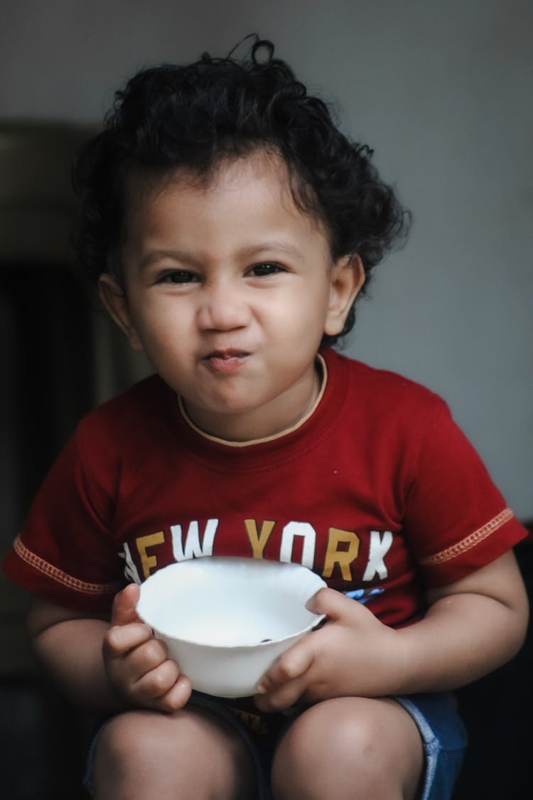 Little Child Eating From A Bowl 