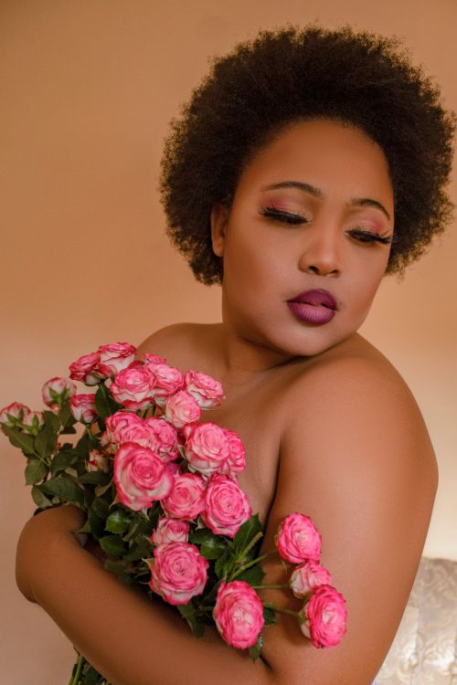 Free A woman elegantly holding a bouquet of pink roses, capturing beauty and grace in a studio setting. Stock Photo