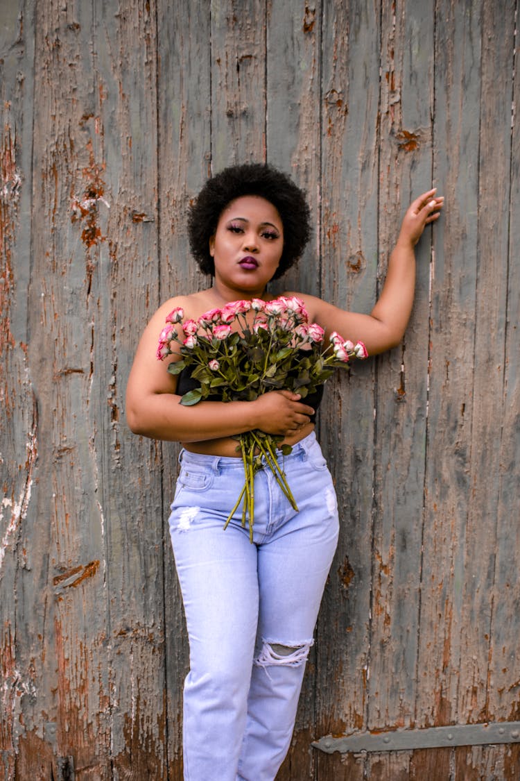 A Woman Covering Her Chest With A Bunch Of Roses