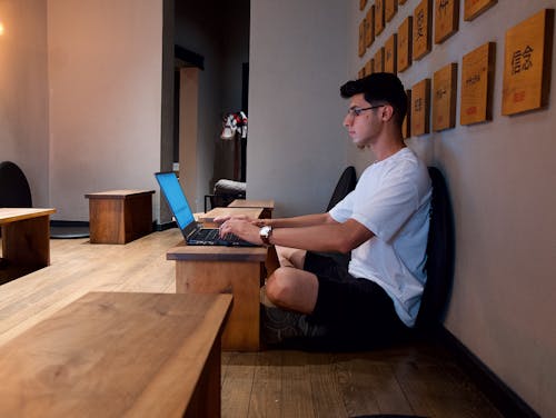 A Man Sitting with a Laptop