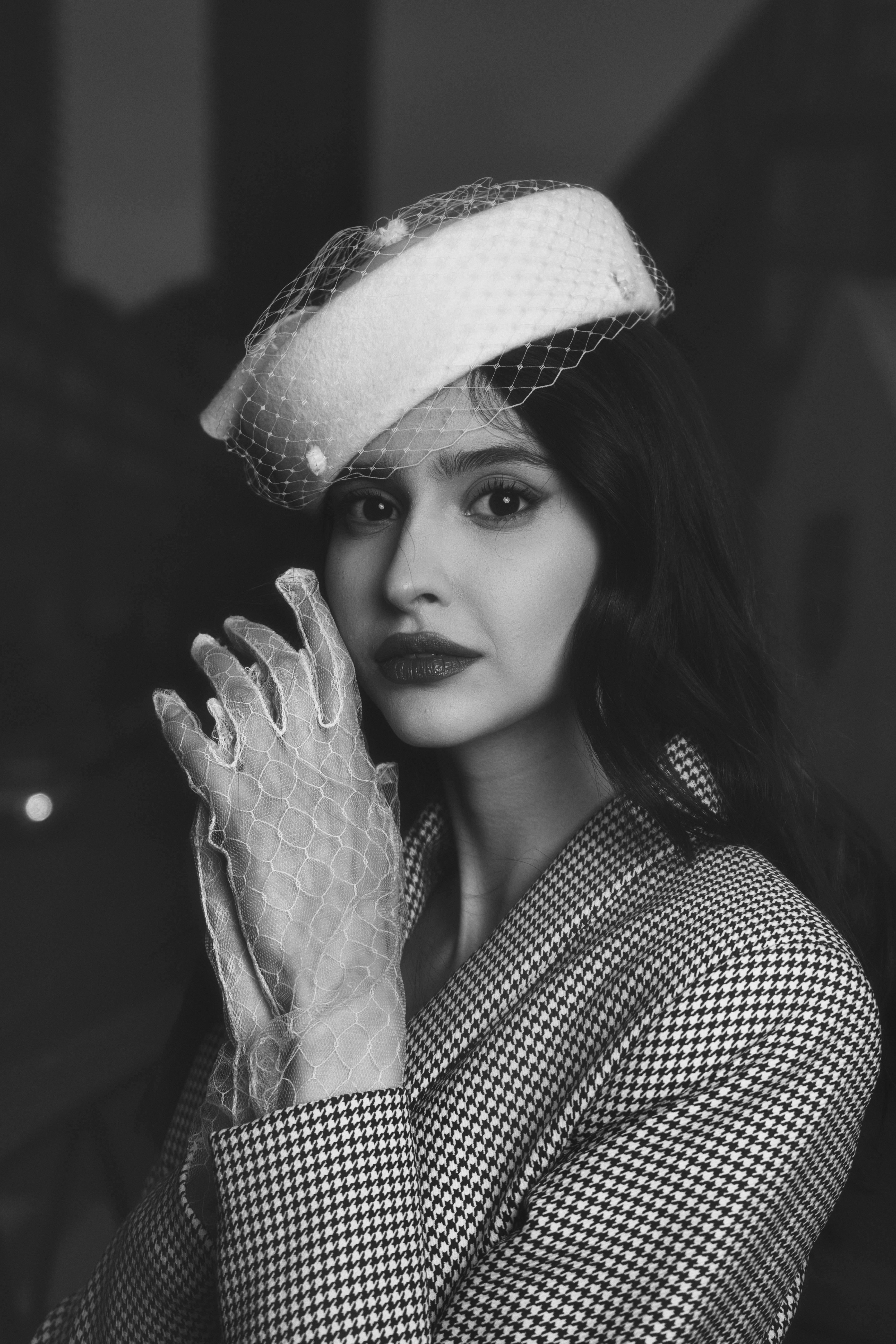 a woman in a hat and gloves posing for a photo